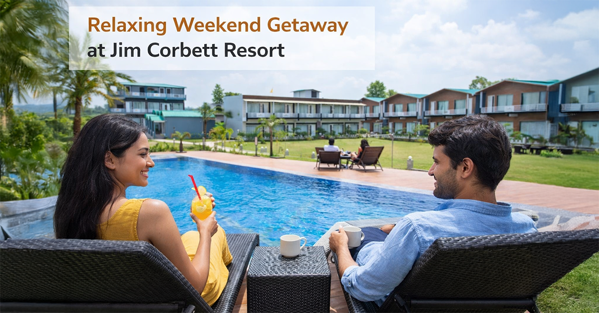 Couple enjoying a relaxing weekend getaway at a Jim Corbett resort, lounging by the pool with scenic views of the resort and lush greenery in Uttarakhand.